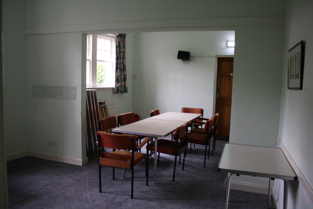 A meeting room with tables and chairs