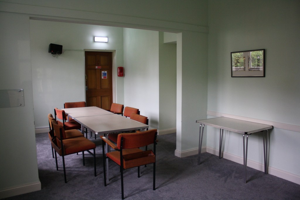 A meeting room with tables and chairs