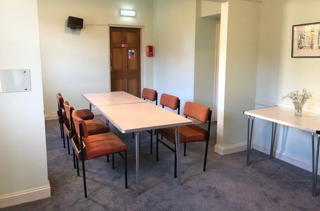 A meeting room with a table and chairs